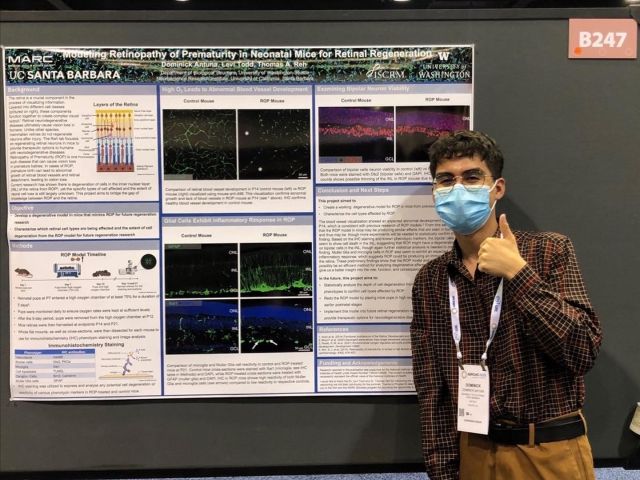 Intern standing next to their poster